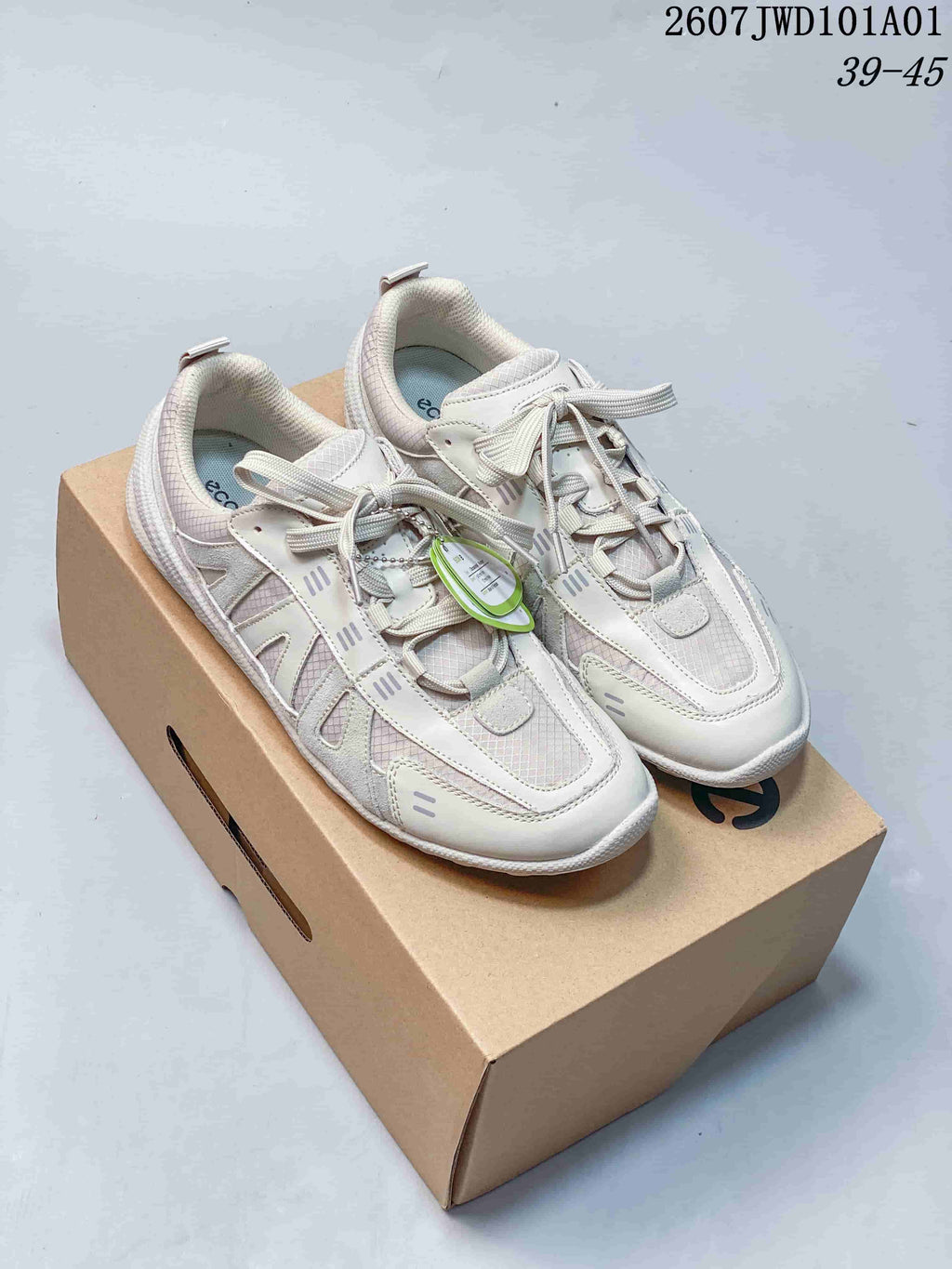 White ECCO-style casual lace-up sneakers displayed on a box; overlay shows style code 2607JWD101A01 and size range 39–45.