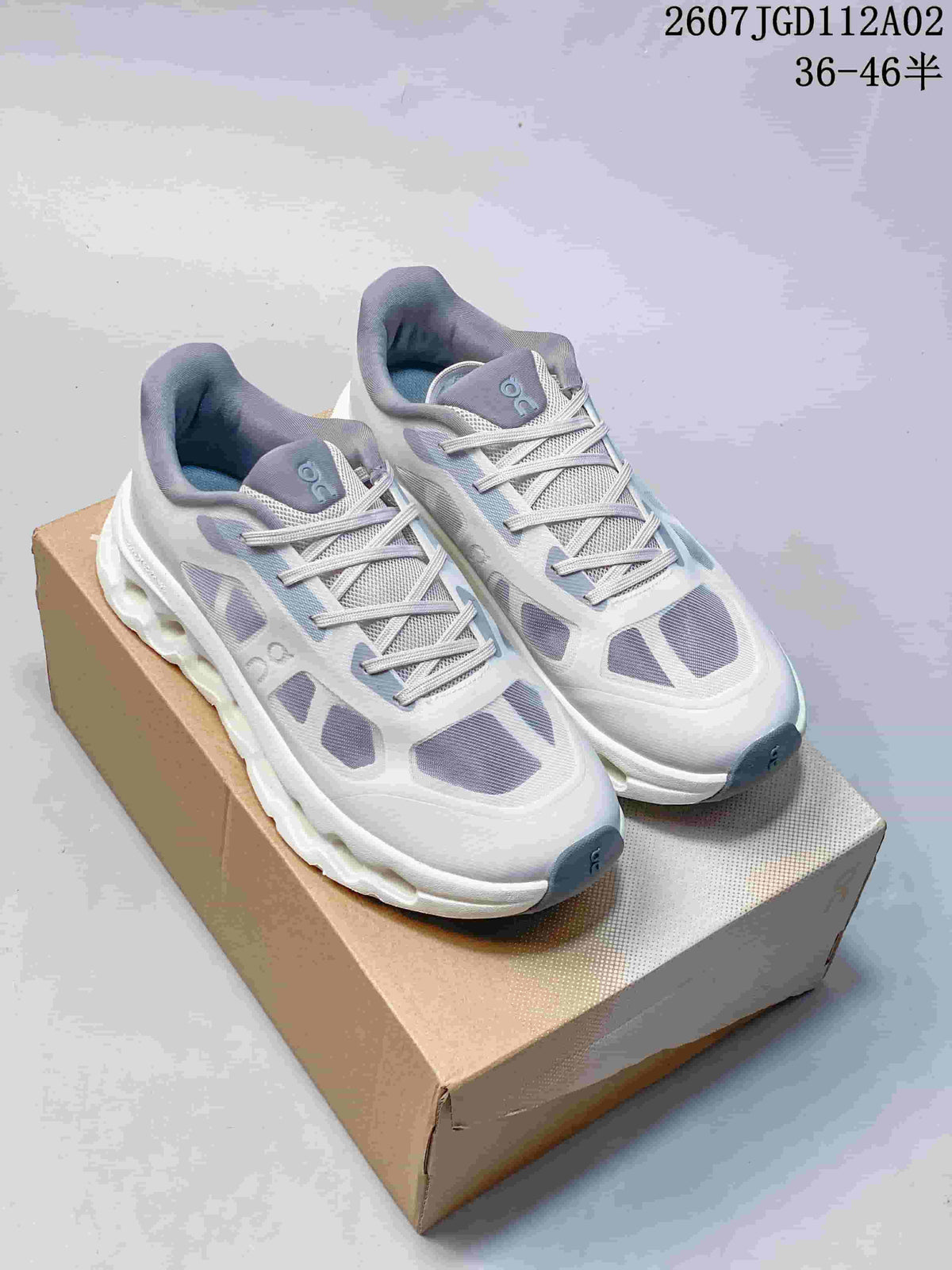Pair of light grey and white Cloudtilt Remix sneakers with purple-grey accents