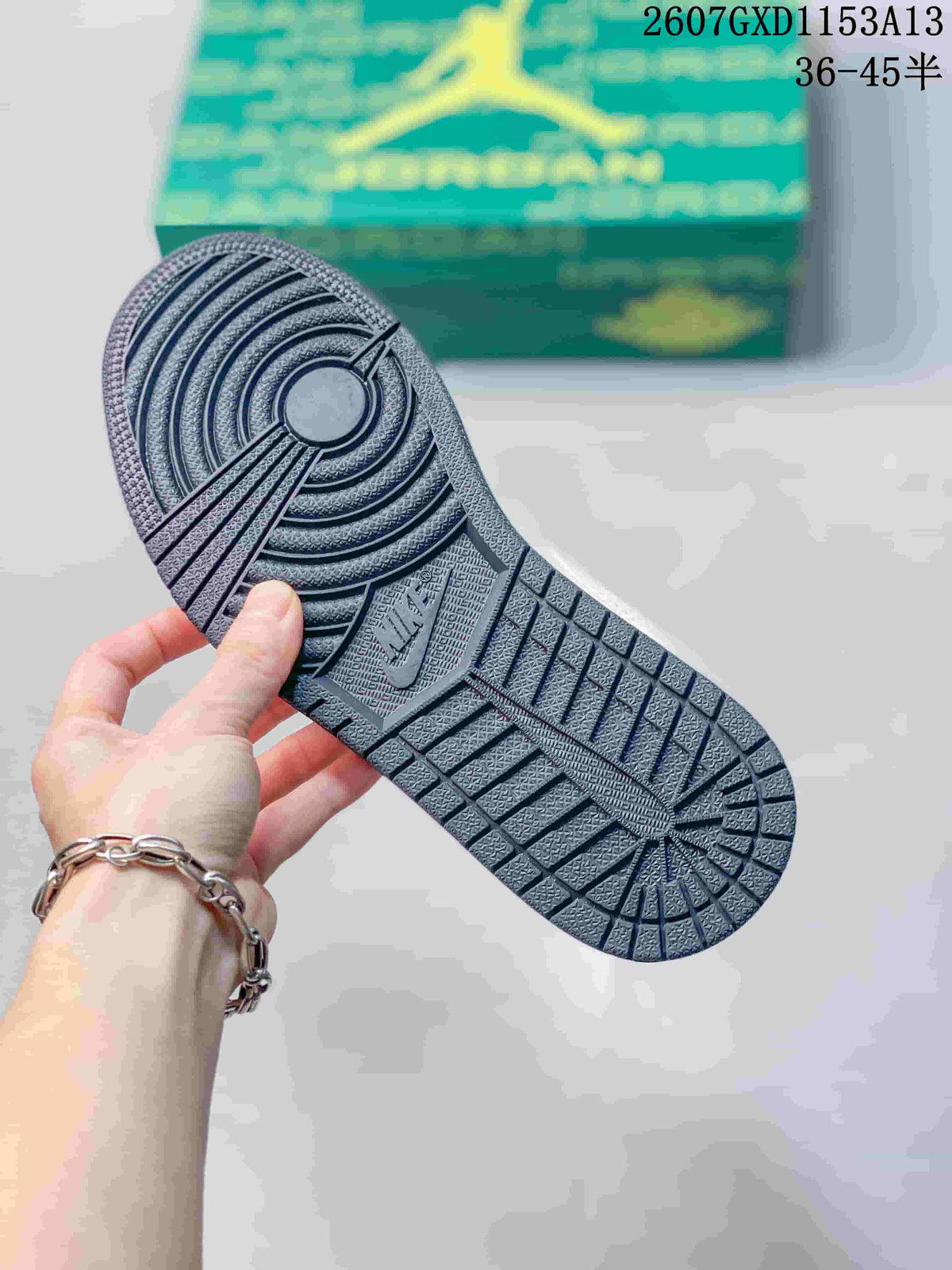 Close view of the dark textured rubber outsole with circular and linear traction patterns.