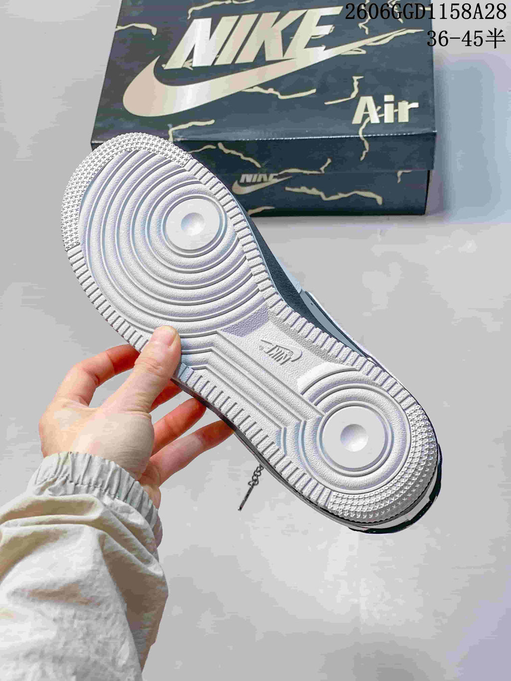 Underside of a sneaker showing a textured white outsole and circular tread pattern.