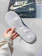 Underside of a sneaker showing a textured white outsole and circular tread pattern.