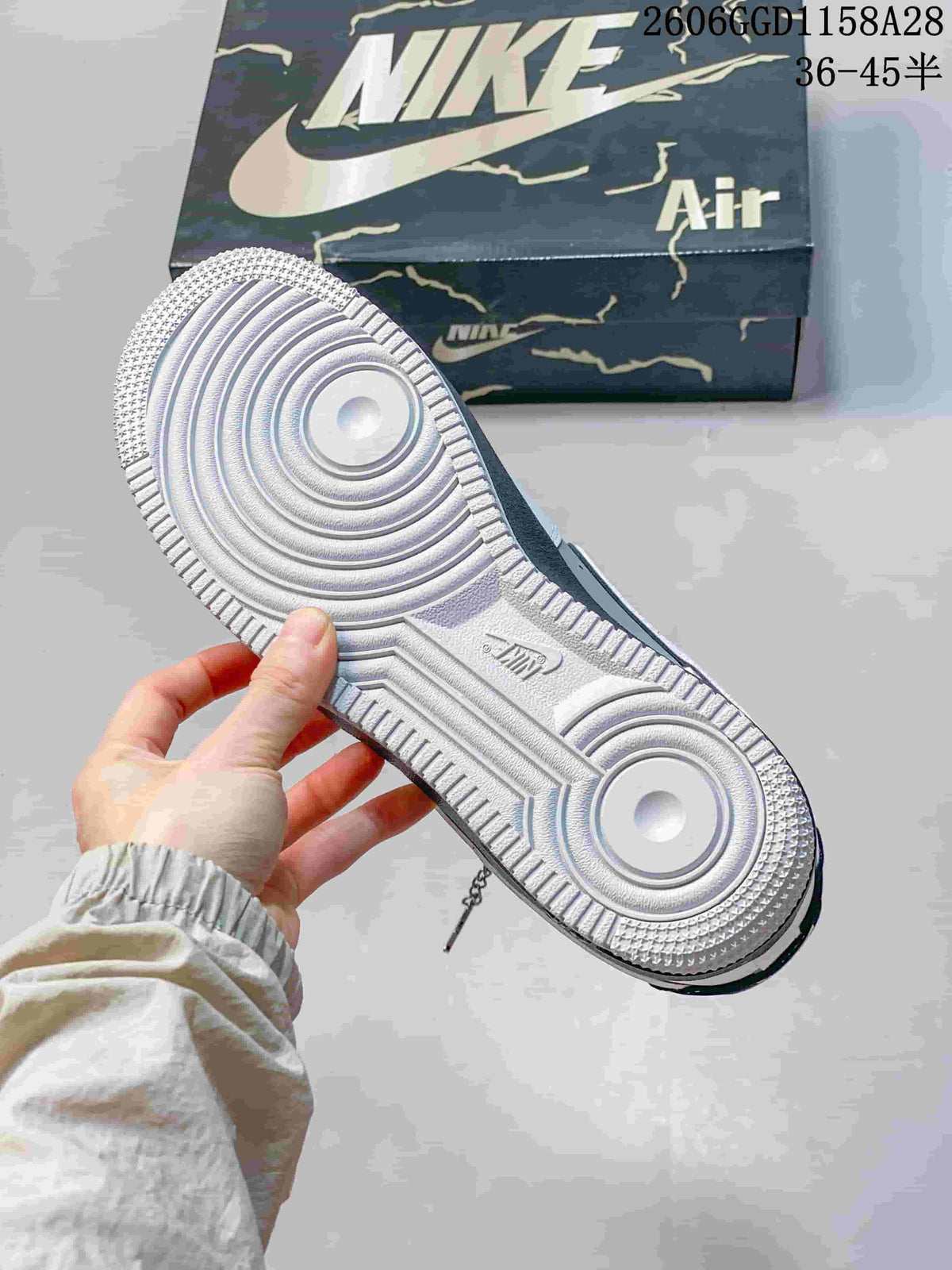 Underside of a sneaker showing a textured white outsole and circular tread pattern.