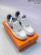 White and gray low-top sneakers with dark accents, patterned laces, and perforated toe panels