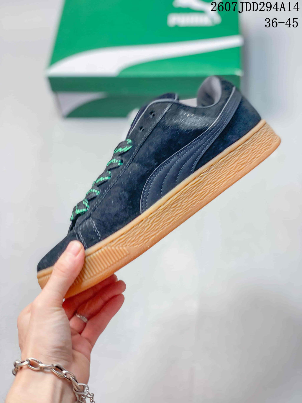 Side profile showing the dark upper, PUMA formstrip, low-top construction, and gum-colored sole.