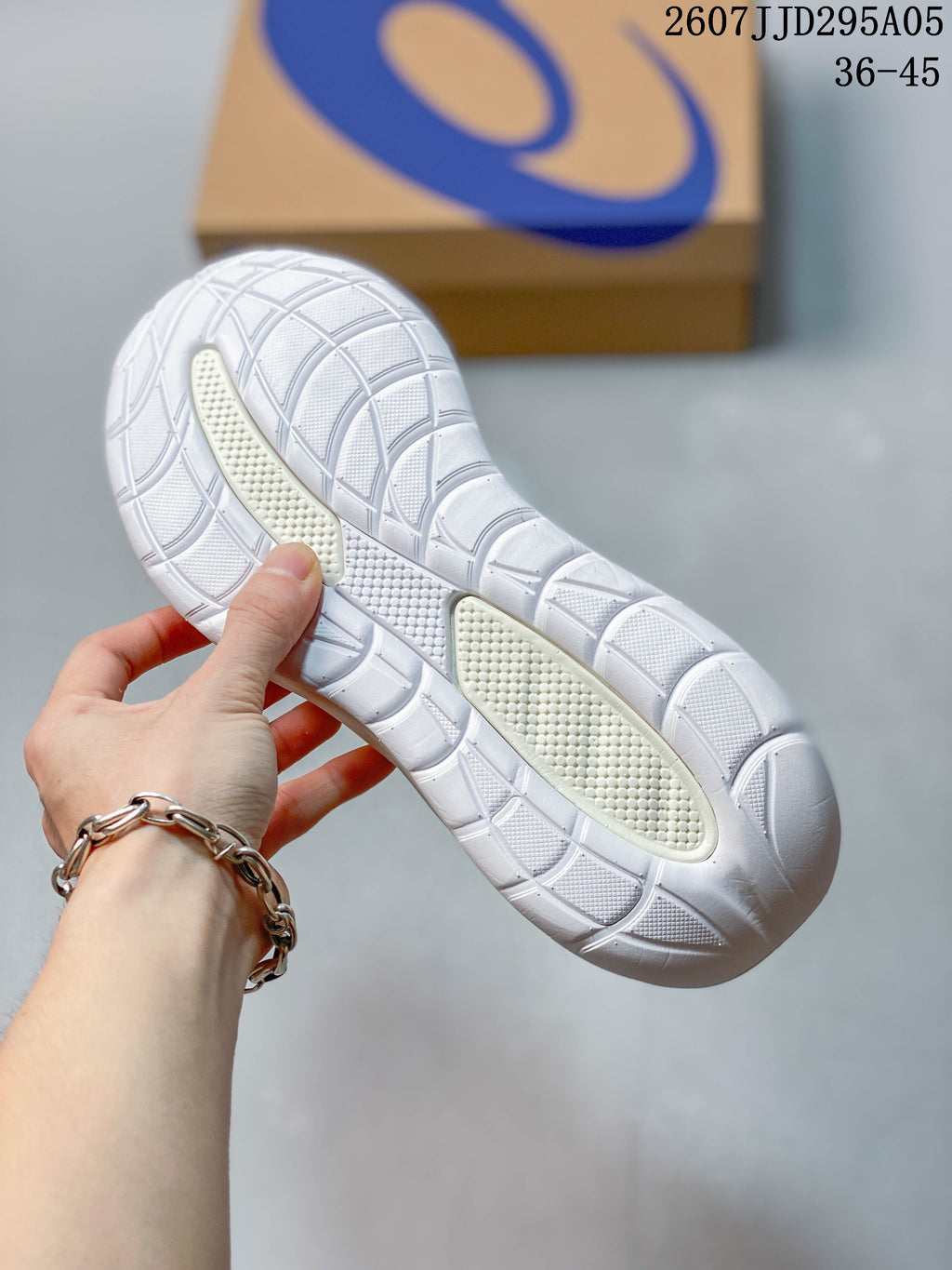 Close-up of the white rubber outsole showing the segmented tread pattern and textured traction areas.