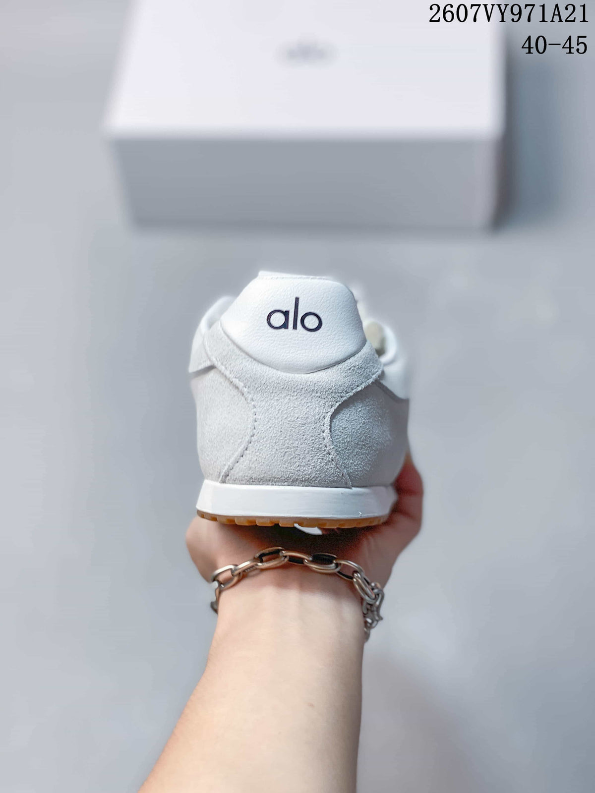 Rear view of the white sneaker showing the padded heel, Alo branding, white midsole, and gum outsole edge.