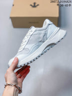 Side view of the white low-top sneaker showing layered panels, a raised midsole and textured outsole.