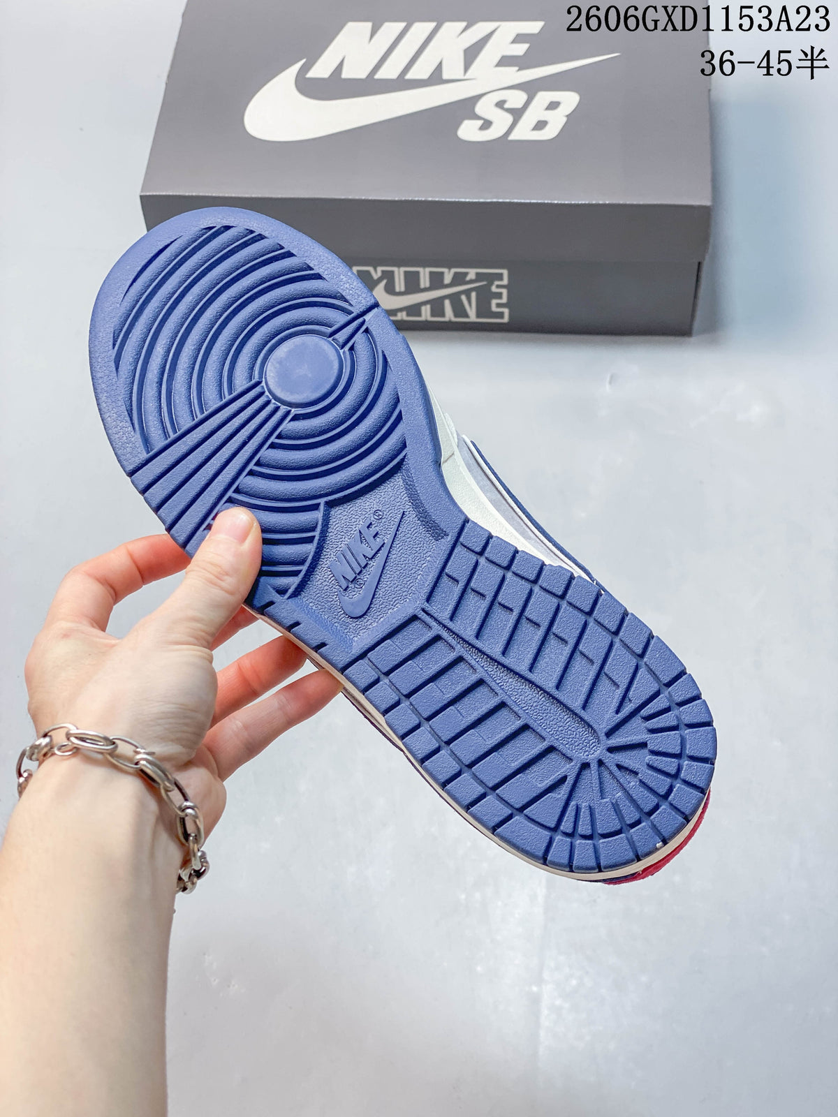 Blue outsole of the Nike SB Dunk sneaker, with the branded shoe box behind it
