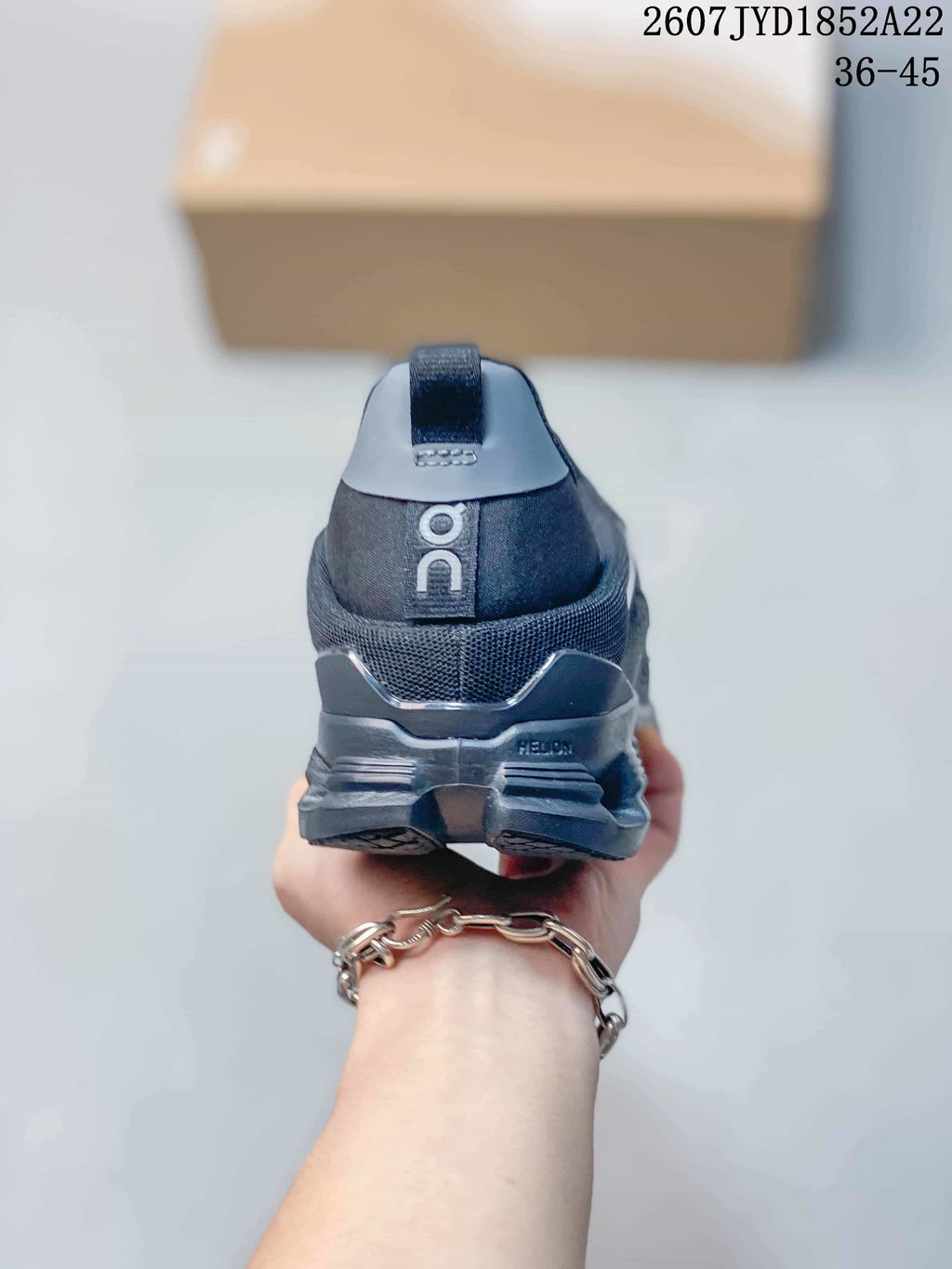 Rear view of a black On sneaker showing the heel pull tab, On branding and structured heel section.