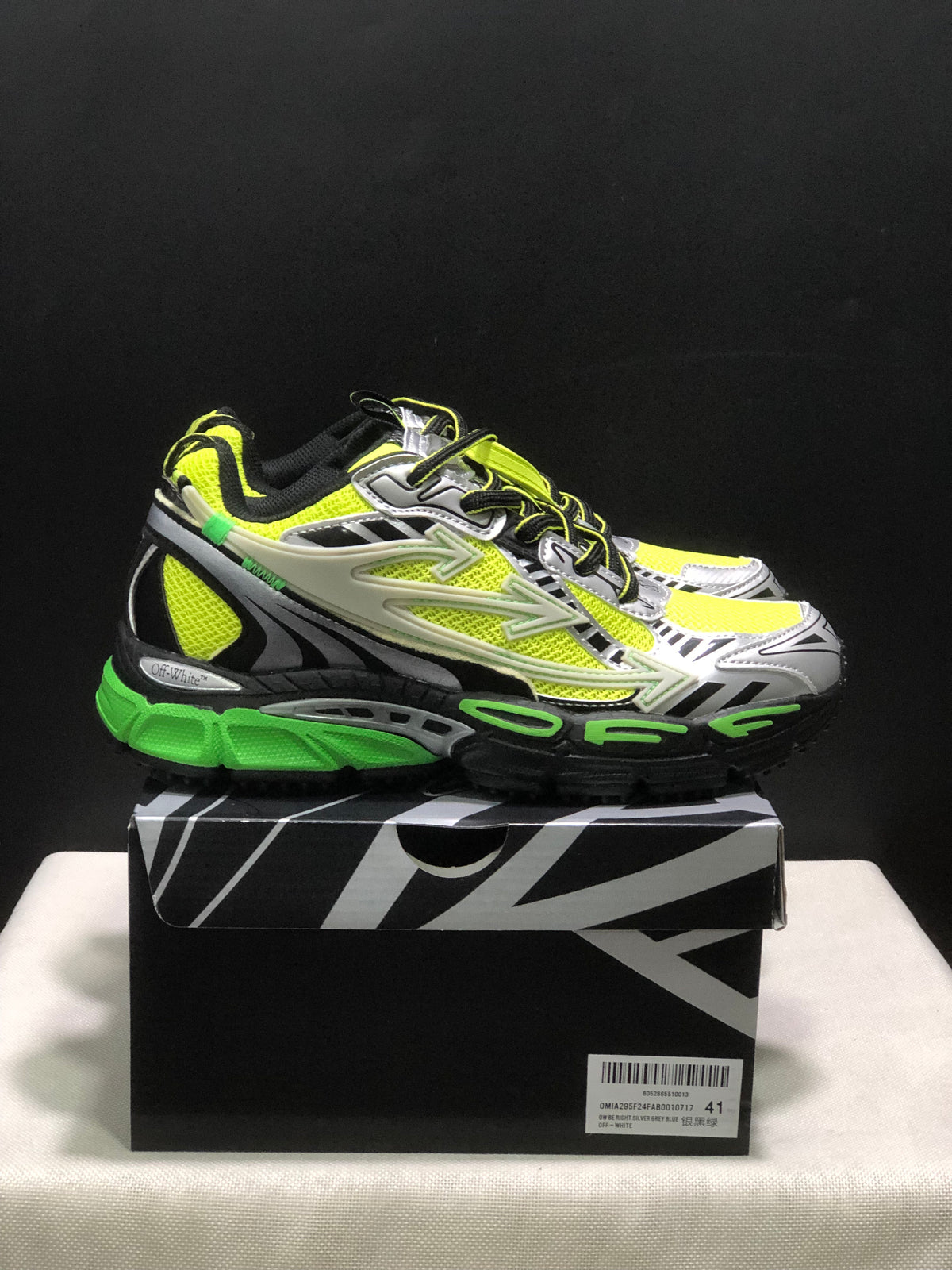Side view of the neon green and black sneakers showing layered panels, arrow-style side detailing, and a sculpted sole.
