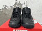 Front view of black Nike high-top sneakers with laces, Swoosh details, and Flight tongue lettering.