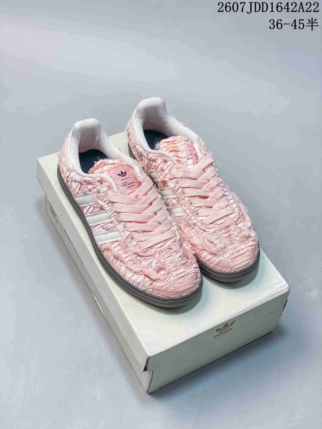 Pink ruched adidas Samba OG sneakers with pale contrast stripes displayed on a shoebox.