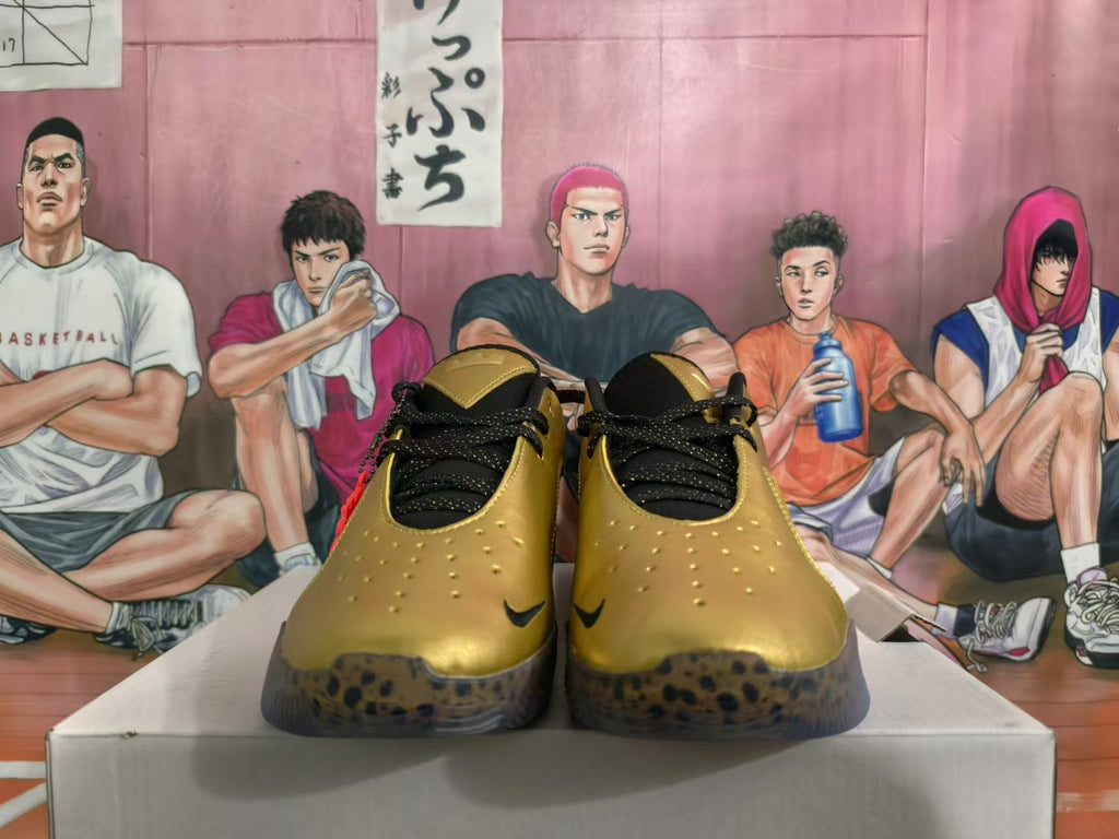 Front view of metallic gold Nike basketball shoes with black laces and spotted outsoles