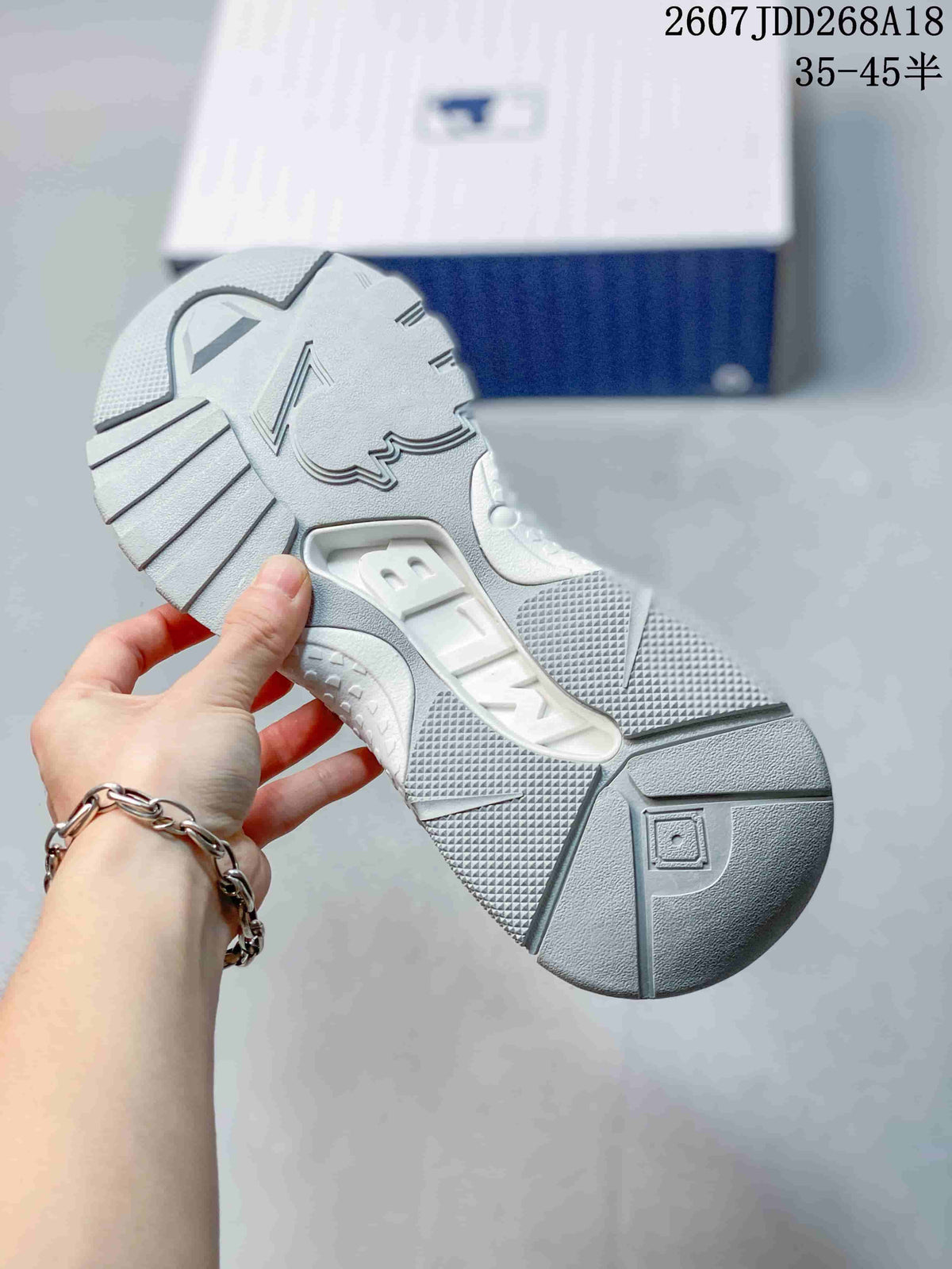 Close view of the sneaker outsole showing segmented textured tread and molded geometric details.