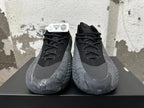 Front view of black lace-up high-top sneakers with sculpted dark gray toe and sole details.