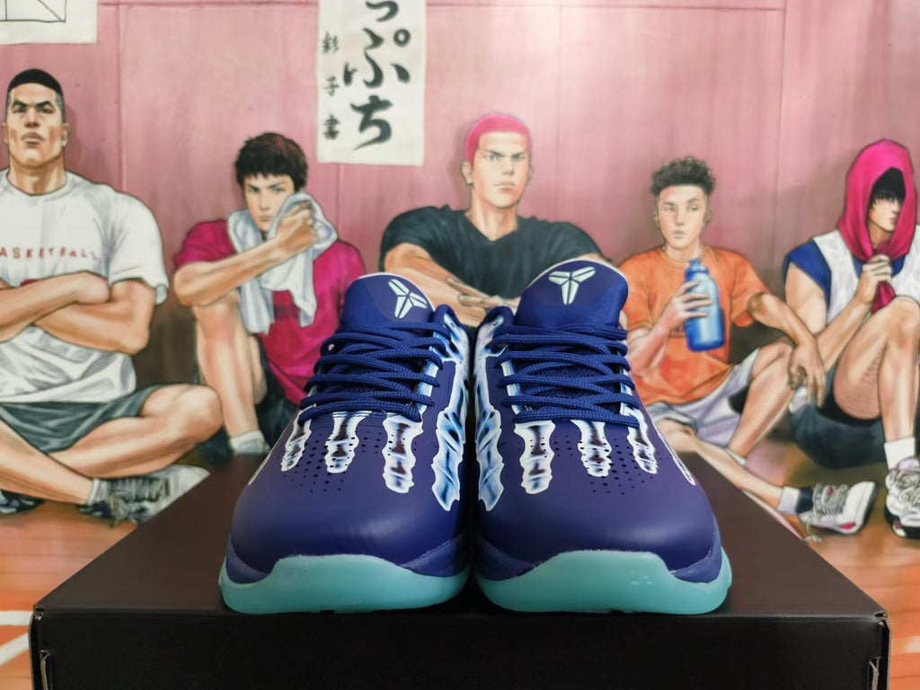 Front view of deep blue basketball shoes with graphic detailing and aqua-colored outsoles