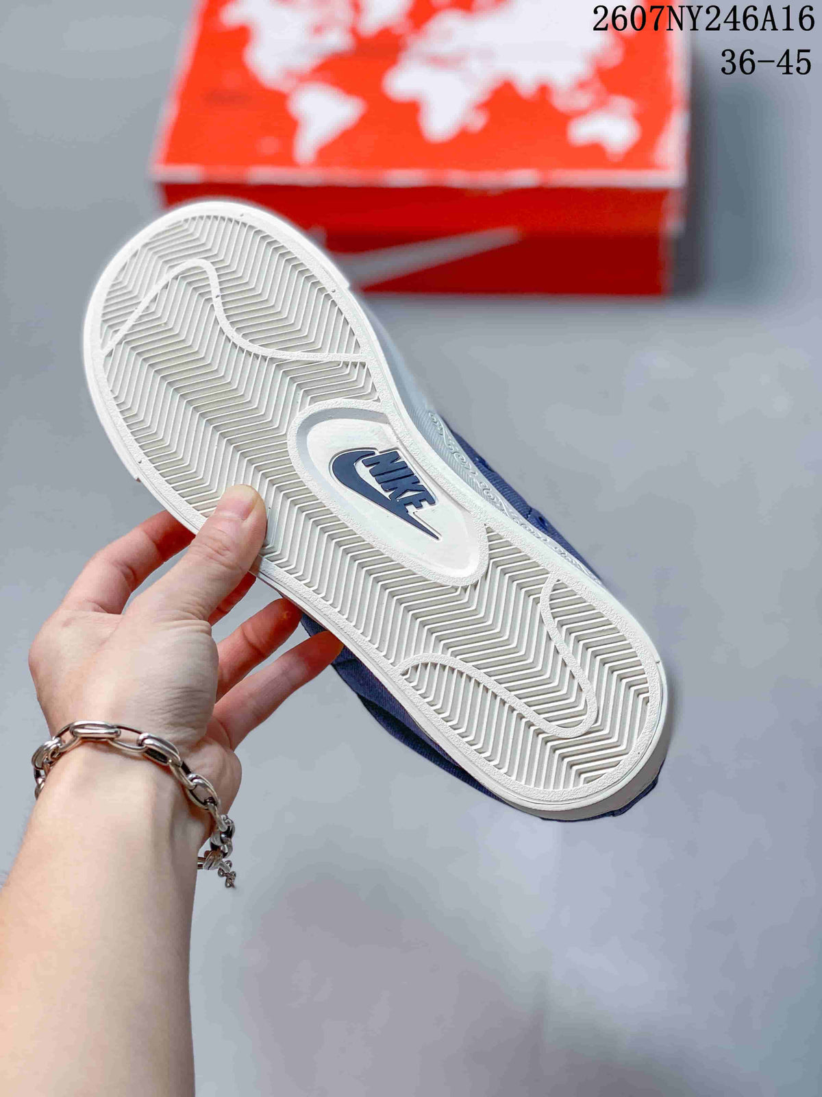 Underside view of a blue sneaker showing the white textured outsole and Nike branding.