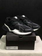 Three-quarter front view of the black and white AMIRI MA Runner sneakers on their shoebox, with a visible size 41 box label.