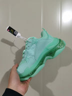 Rear-side view of the mint green Balenciaga sneaker highlighting the clear sole sections and tonal overlays.