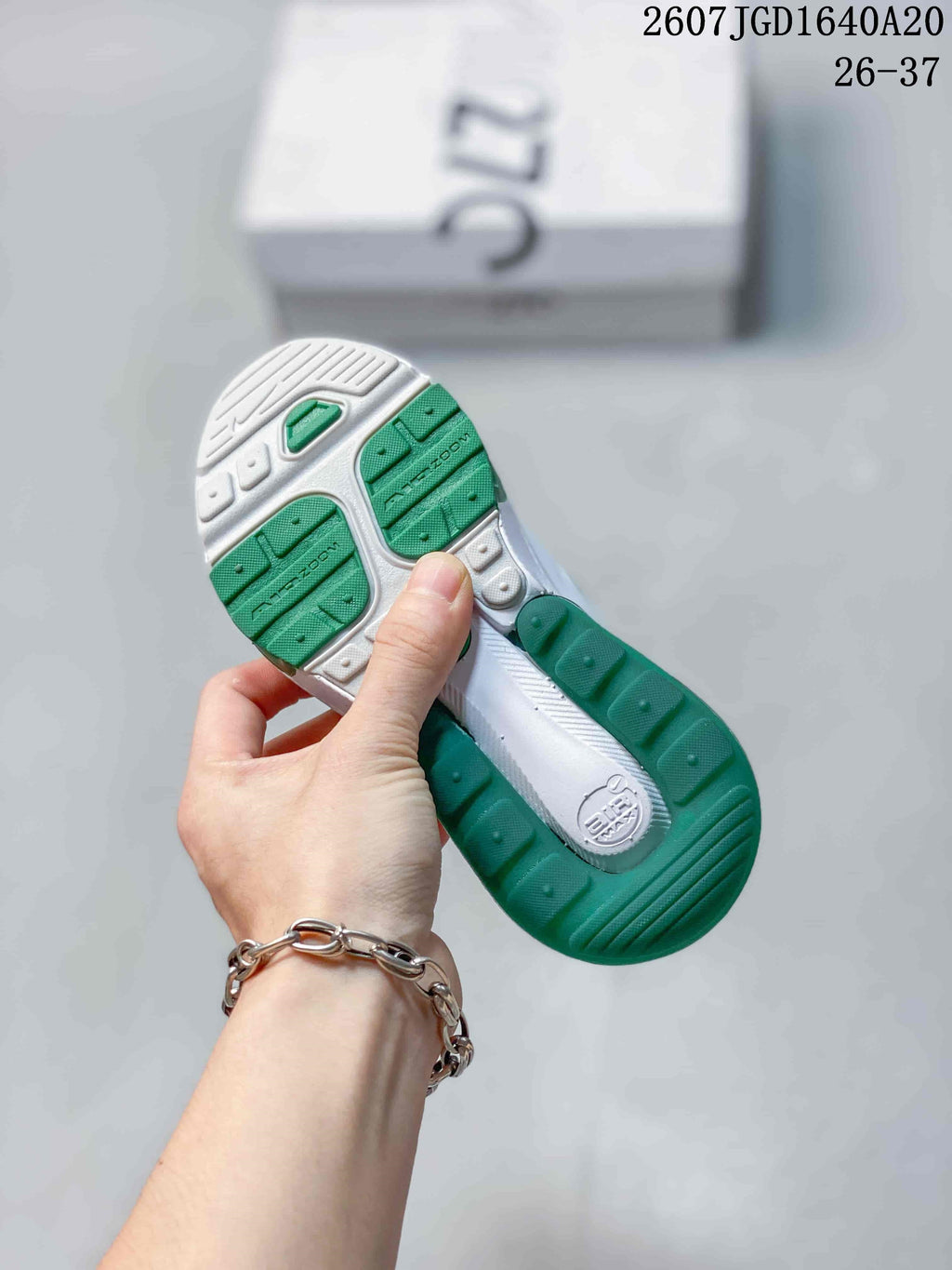Underside view showing the white and green patterned outsole and heel cushioning unit.