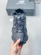Front view of a dark grey New Balance 9060 sneaker showing the mesh toe area, laces and tongue branding.