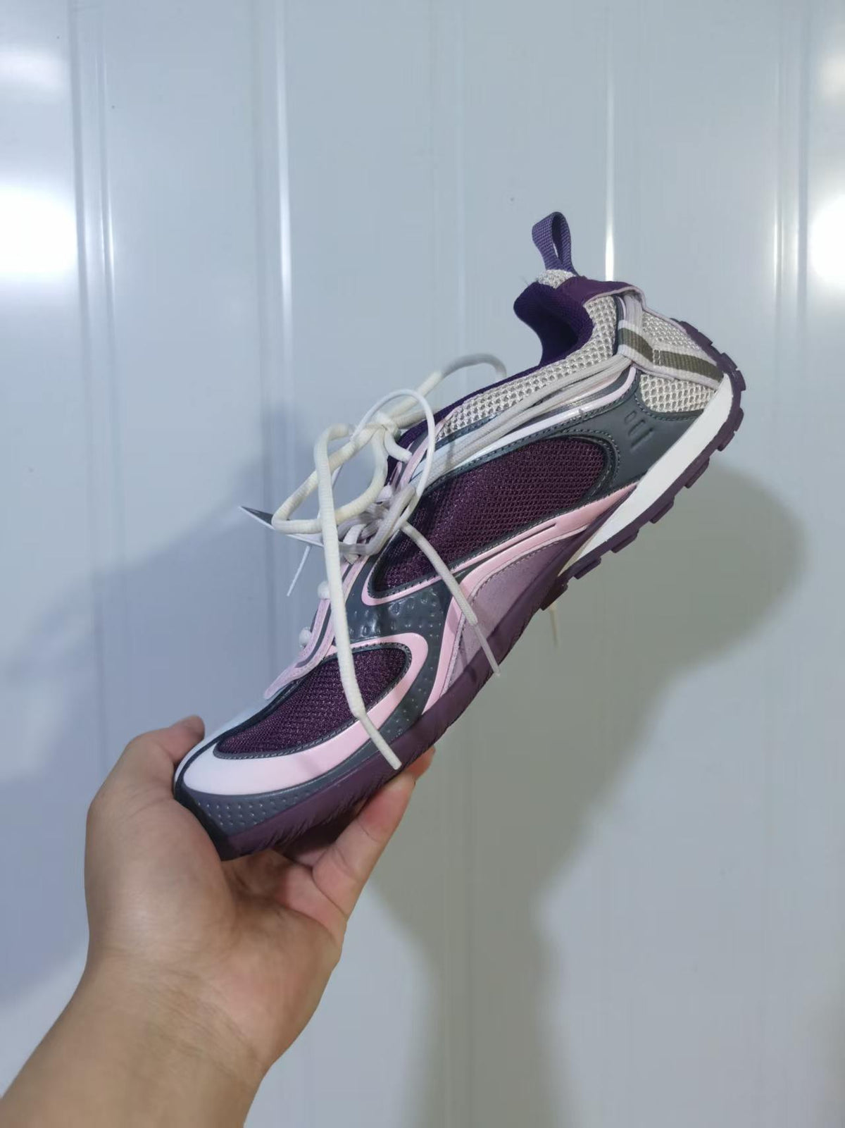 Top and angled view of the Skechers 5159 sneaker showing the layered upper, mesh sections, cream laces, and purple outsole.