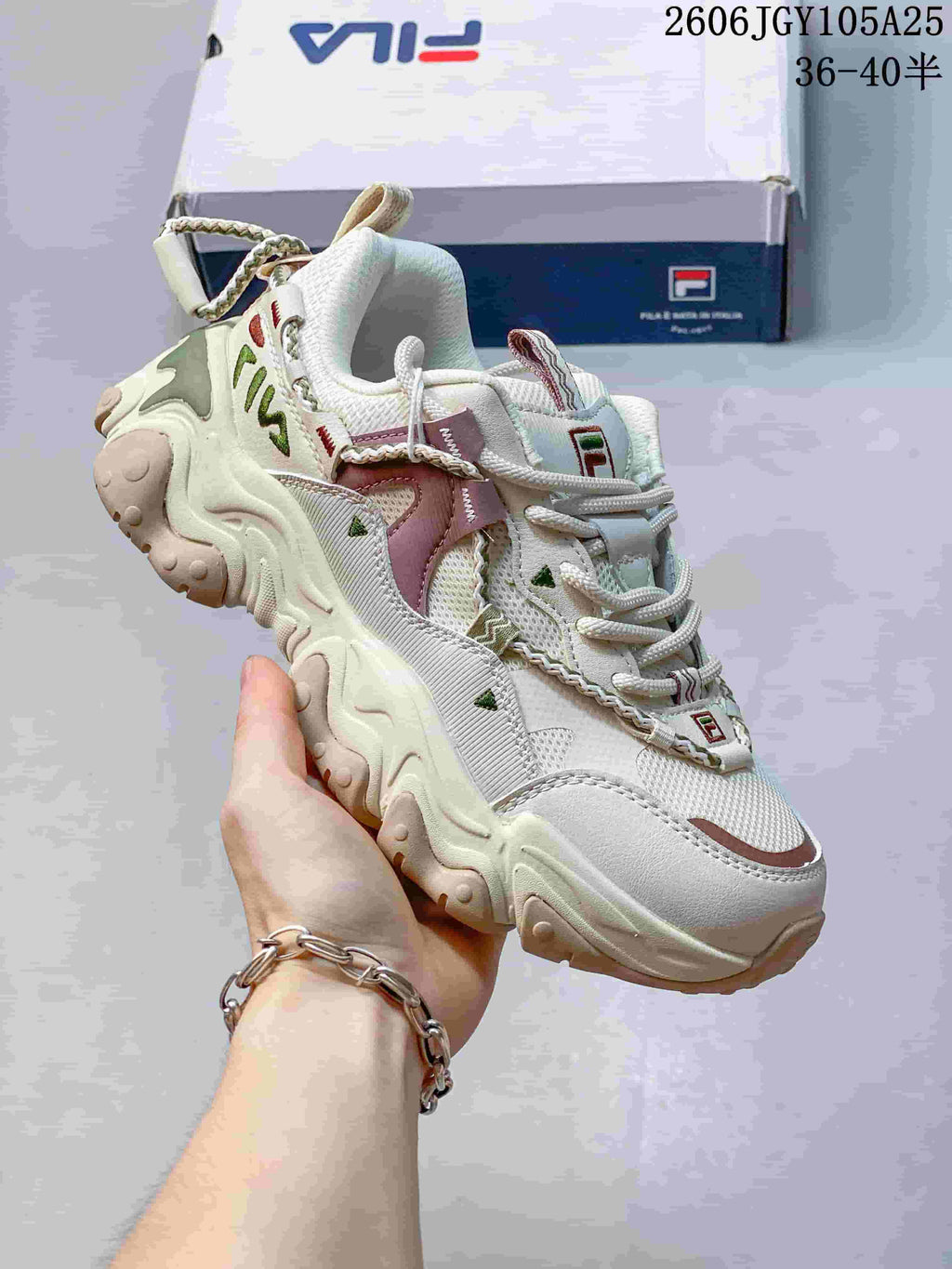 Angled view of a cream FILA Fusion chunky sneaker with layered overlays