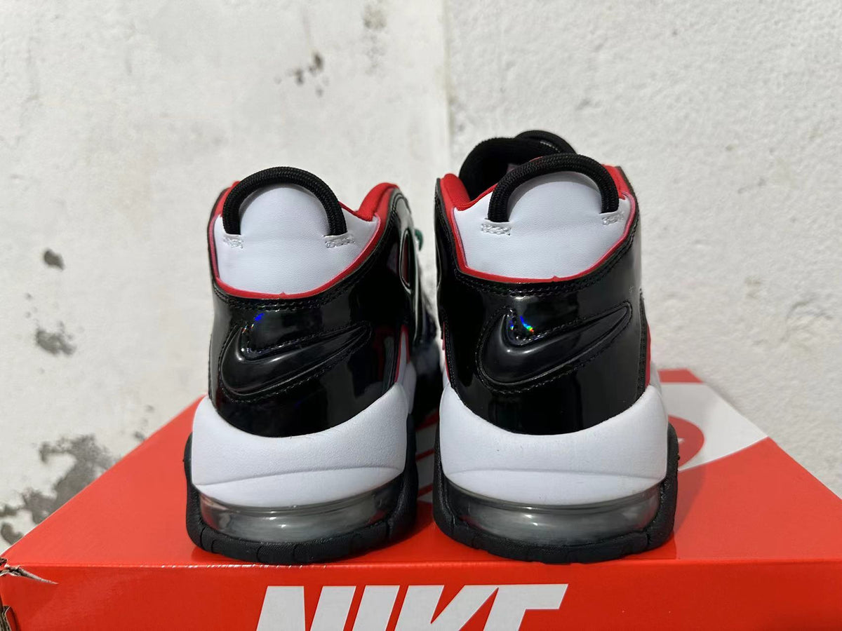 Rear view of white and black Nike sneakers with red trim and visible sole cushioning.
