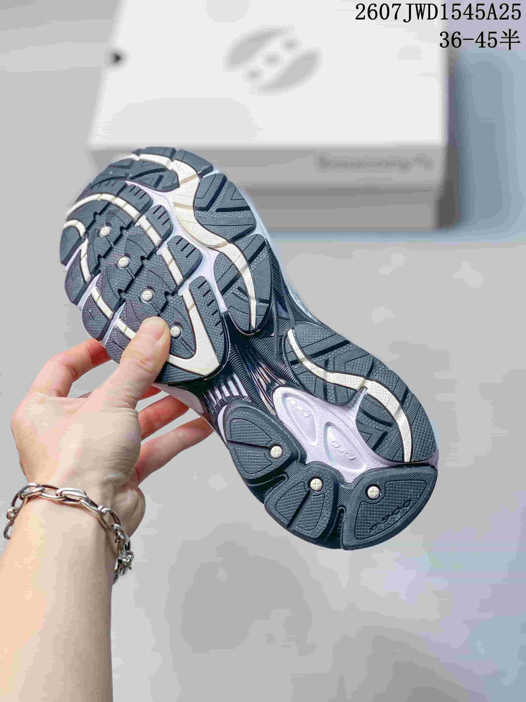 Underside view of a Saucony sneaker showing the dark patterned rubber outsole.