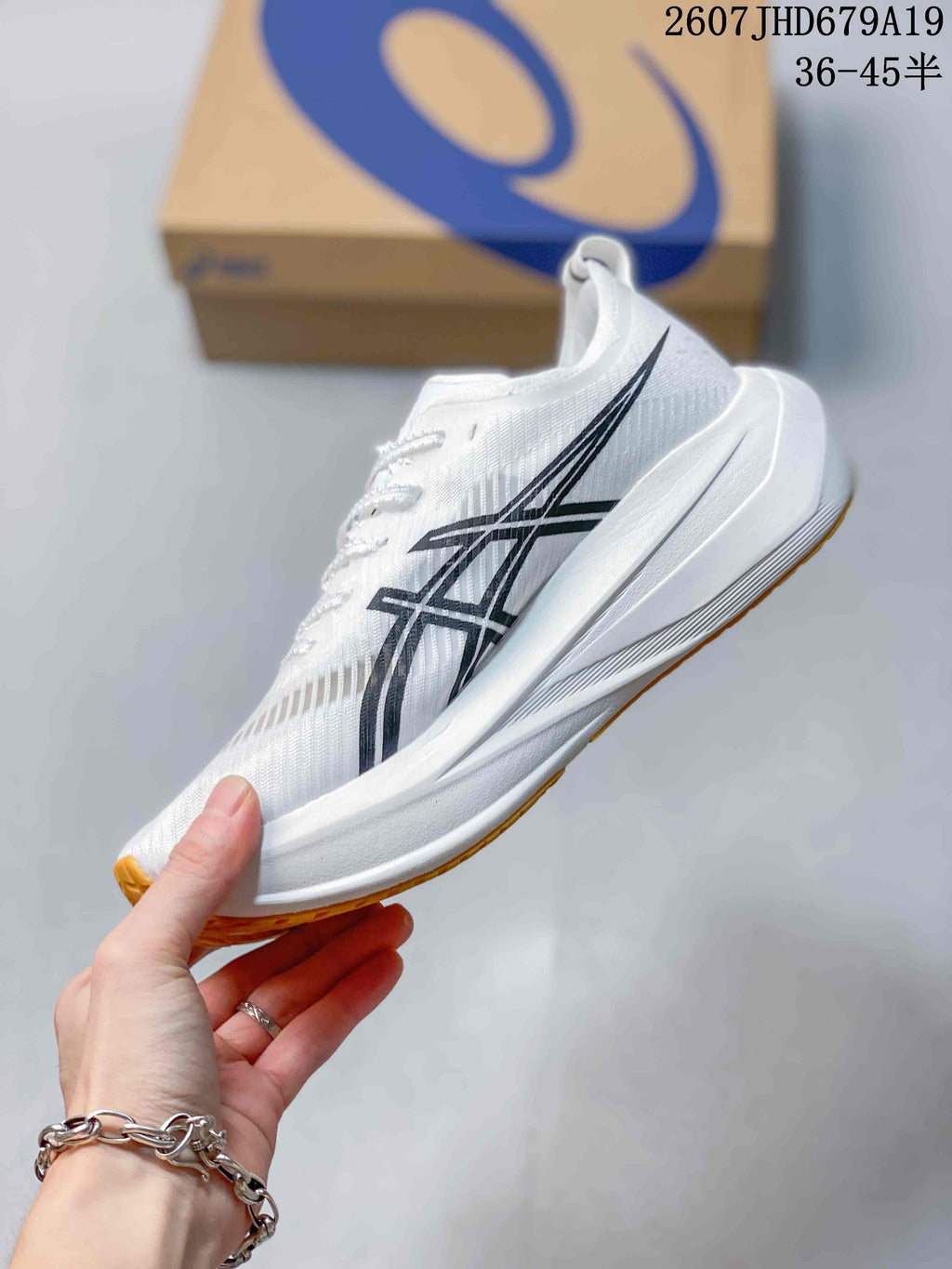 Side view of the white ASICS running shoe showing black branding, gray upper detailing, and the raised white sole.