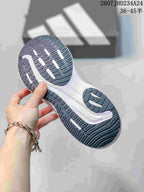 Close view of the dark rubber outsole with segmented traction grooves and white accent sections.