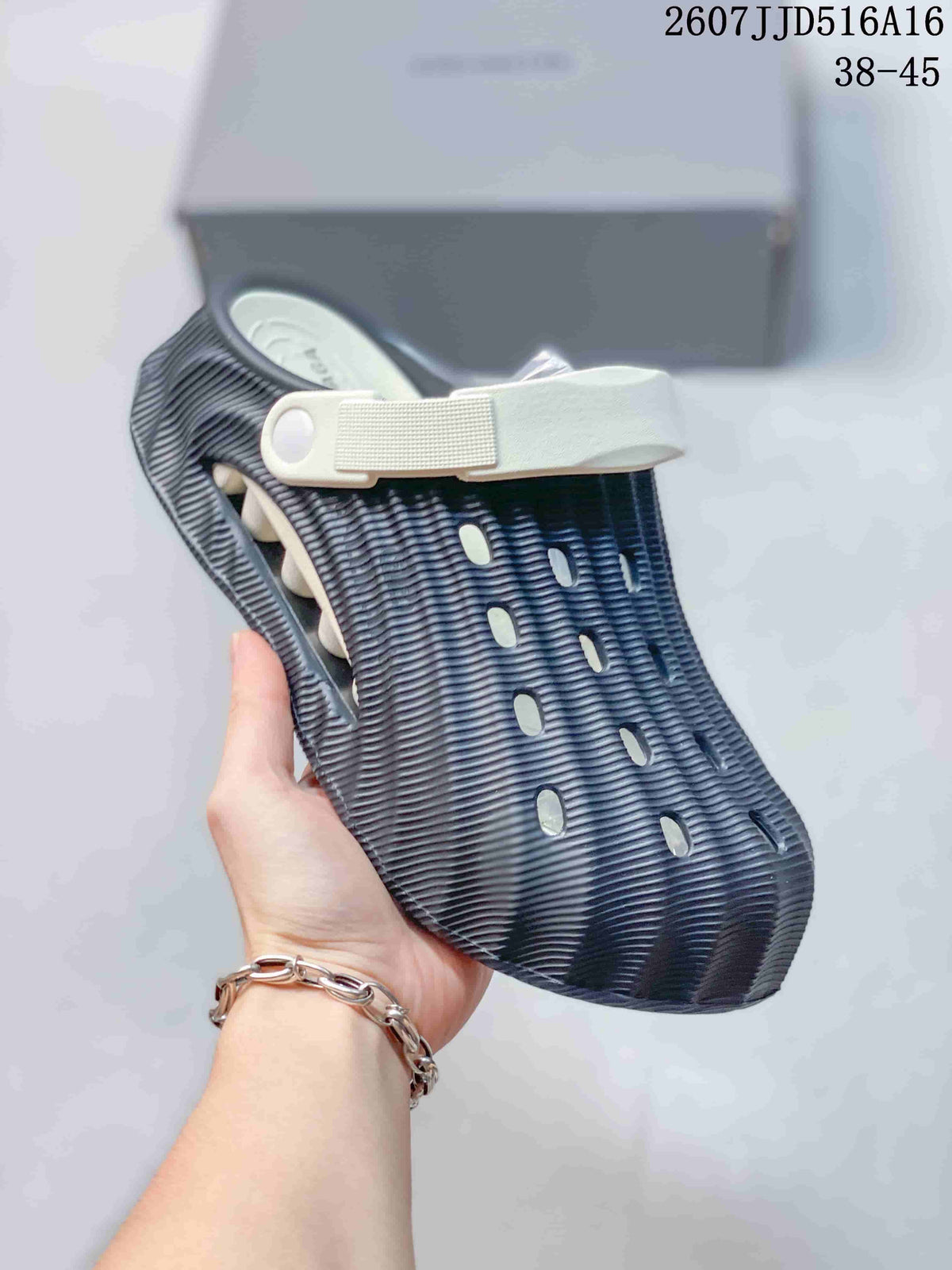 Side view of a navy and white clog showing the rear strap, ventilation openings, and ridged exterior.