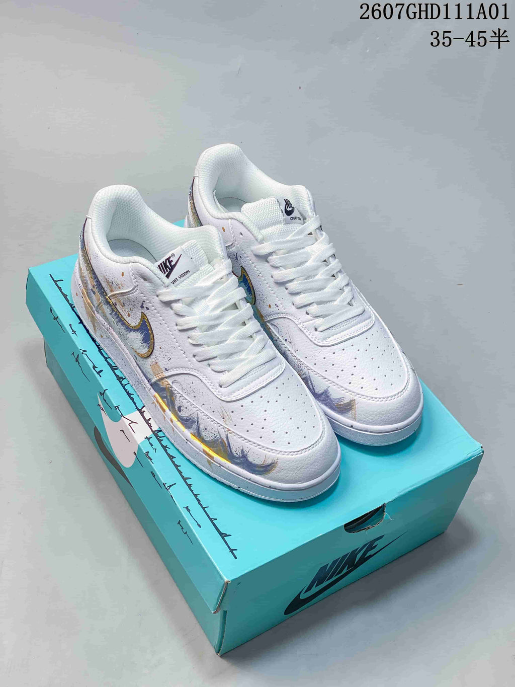 Pair of white Nike Court Vision low-top sneakers with colorful graphics and white laces