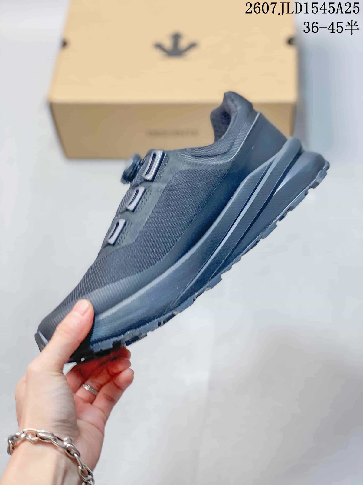 Side view of the black DESCENTE sneaker showing the mesh upper, layered overlays, midsole, and treaded outsole.