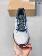 Top-down view of the white toe box, black laces, dark tongue, and On logos.