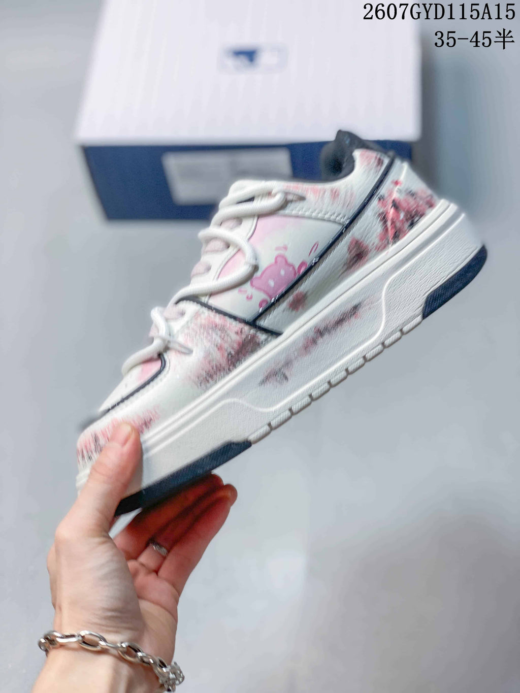 Side profile of the sneaker showing the raised platform sole, pale pink panels and distressed graphic detailing.
