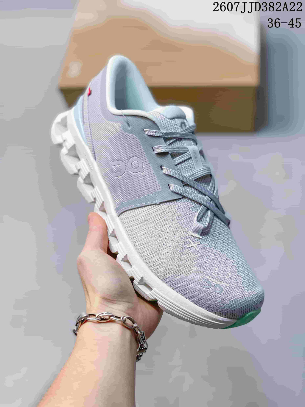 Angled side view of the gray and mint On sneaker showing the lace system, side logo and segmented sole.