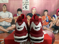Rear view of red and white Nike sneakers showing black swoosh logos, heel branding, and a visible heel window.