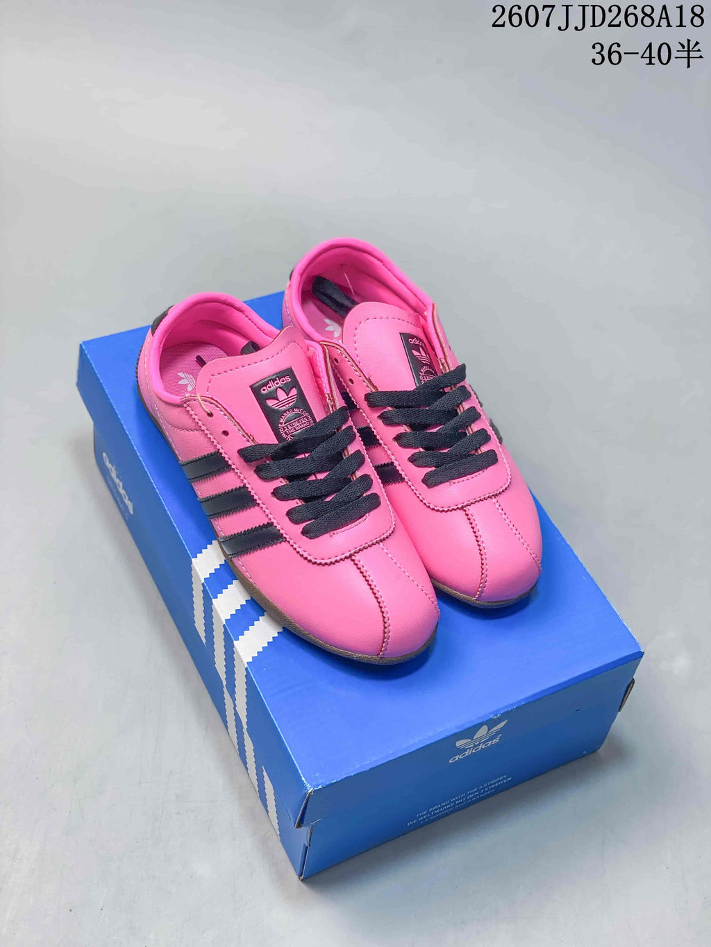 Pink adidas Originals Tokyo low-top sneakers with black stripes and black laces displayed on a blue adidas shoe box; overlay text shows style 2607JJD268A18 and size range 36–40.5.