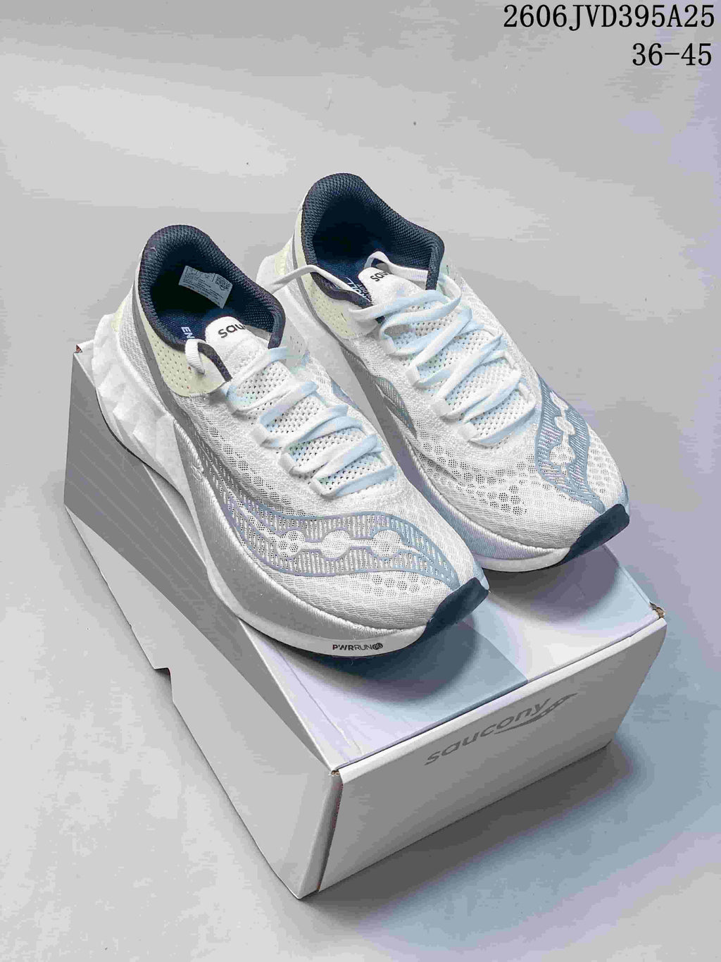 Pair of white Saucony running shoes with pale blue-gray details and dark lining; image text states 36–45.