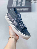 Angled side view showing the black upper, patterned laces, branded side detailing and white sole.