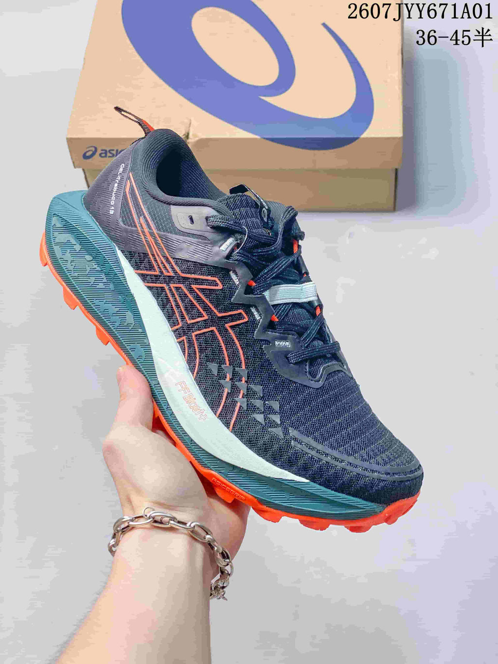 Navy ASICS GEL-TRABUCO 13 trail shoe with orange accents and a lugged outsole