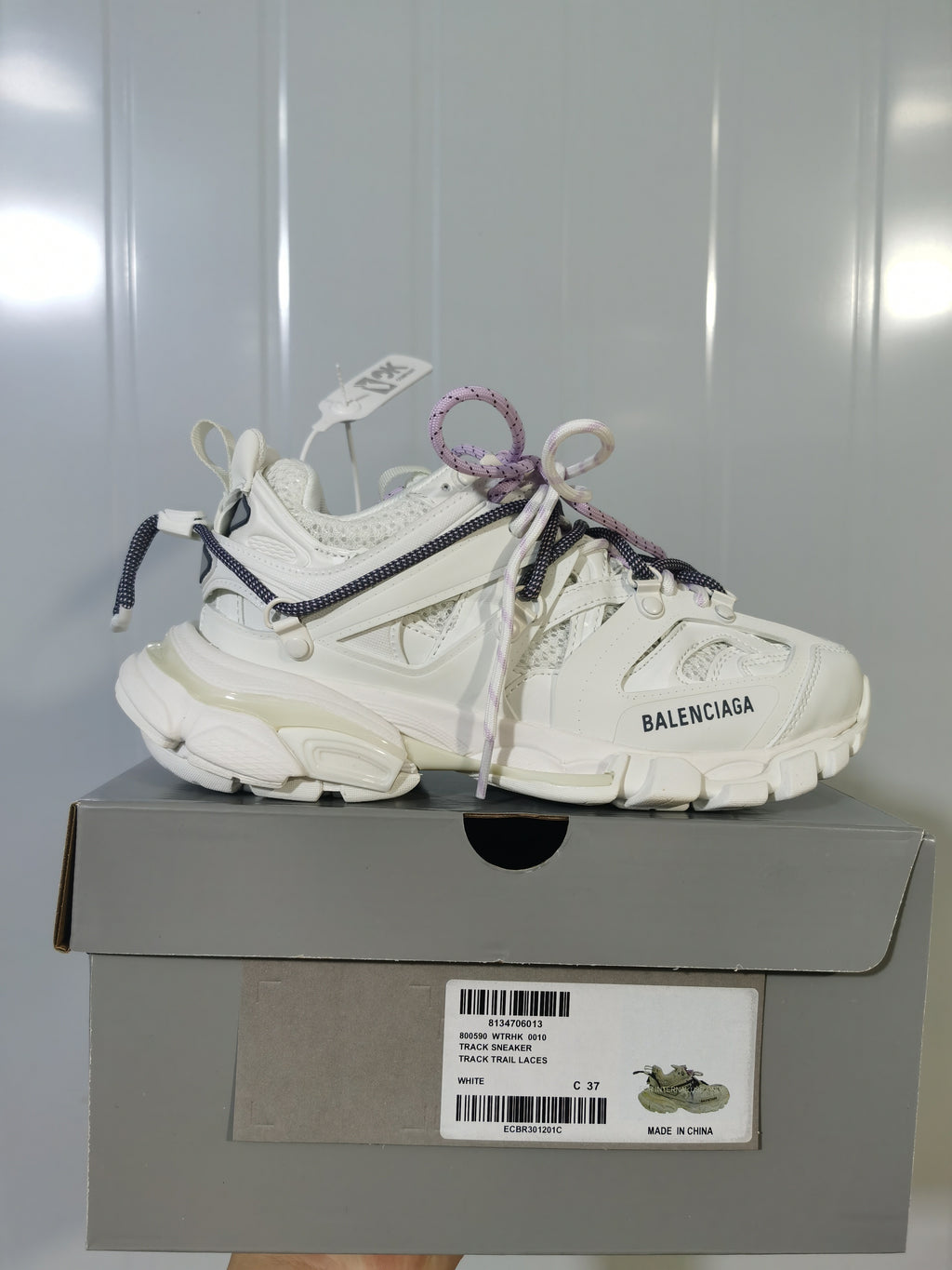 White Balenciaga Track Trail sneaker displayed on a gray shoe box; the box label shows Track Trail Laces, White, and size C 37.
