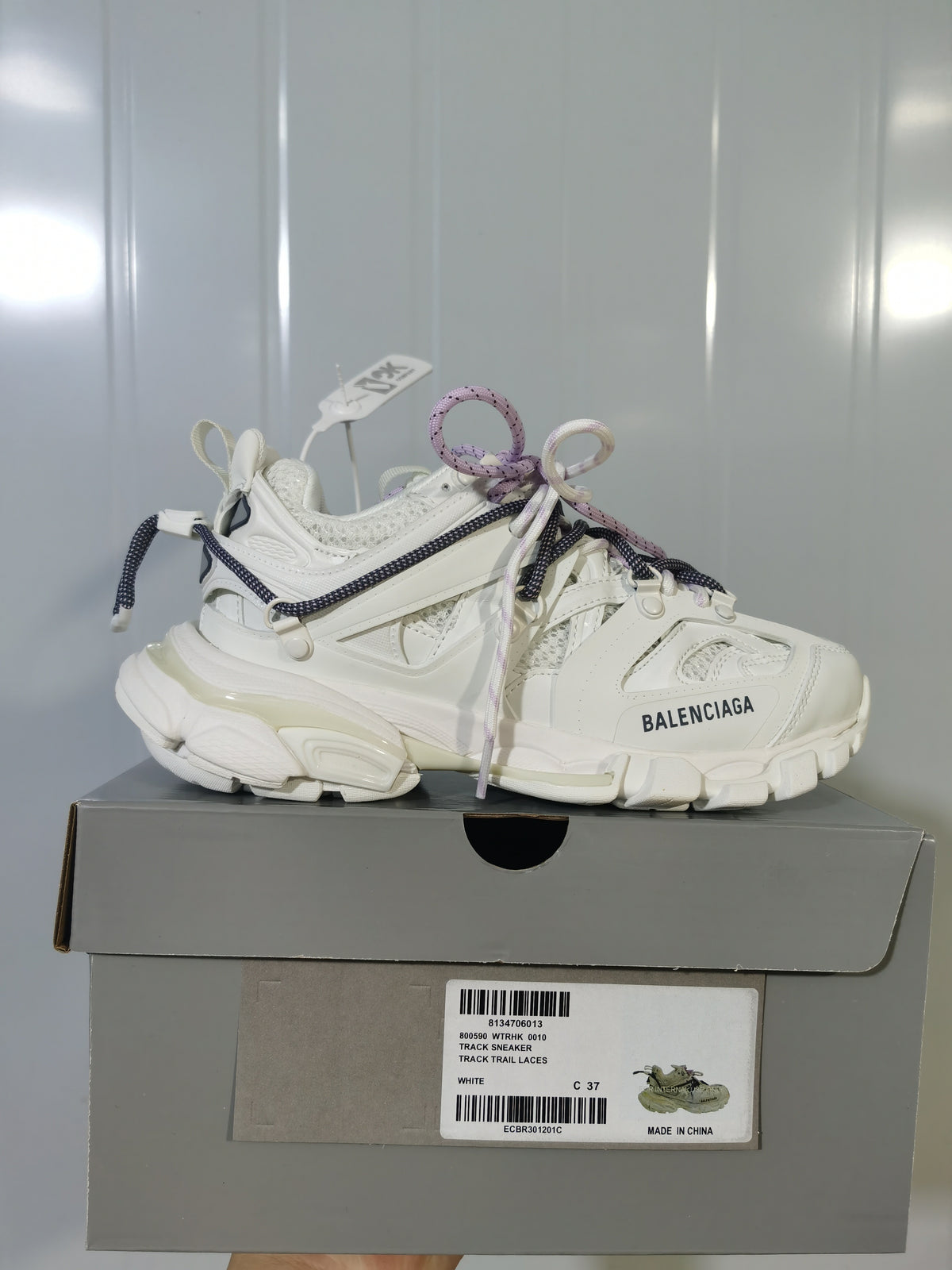 White Balenciaga Track Trail sneaker displayed on a gray shoe box; the box label shows Track Trail Laces, White, and size C 37.