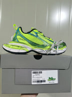Side profile of the fluorescent yellow and blue sneaker displayed on its box, with the product label visible below.