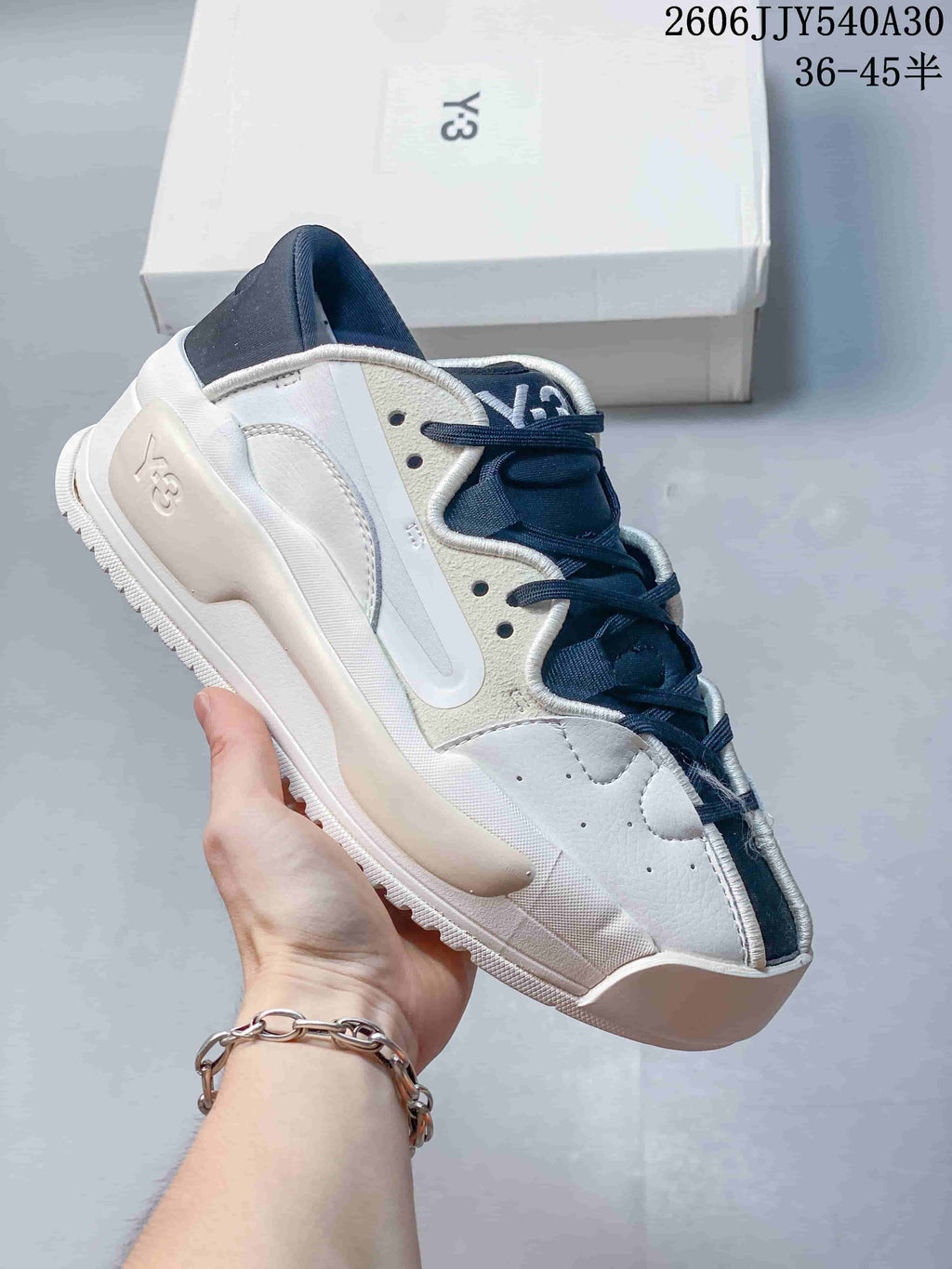 White and navy Y-3 Rivalry sneaker with layered side panels and a sculpted sole.