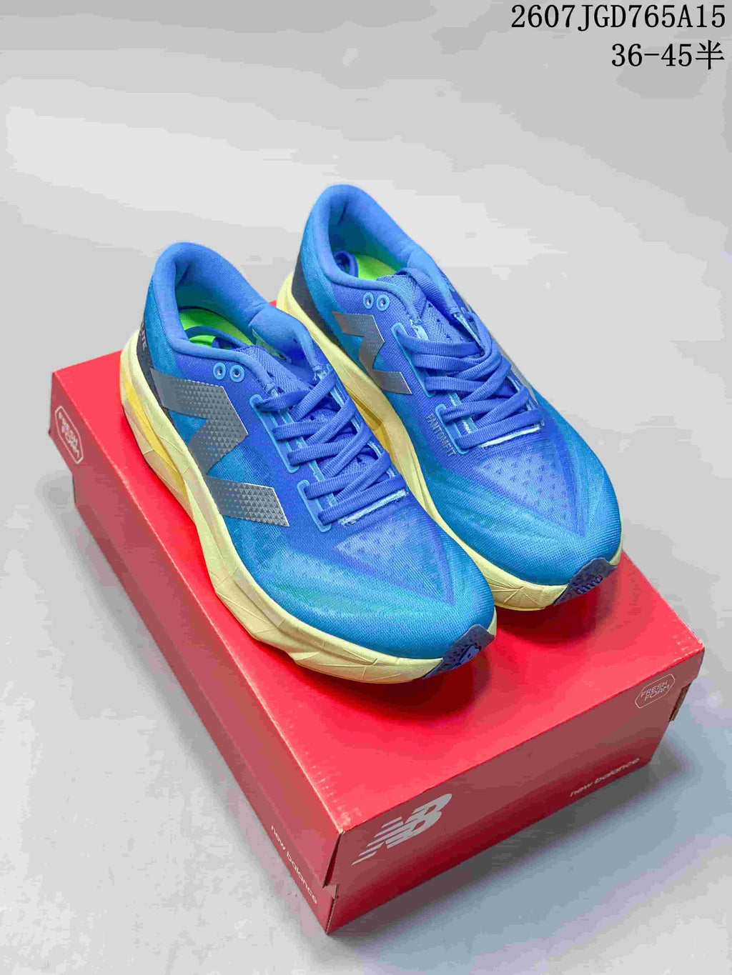 Pair of blue and pale yellow New Balance running shoes displayed on a red shoe box; overlay text shows style code 2607TGD765A15 and size range 36–45.