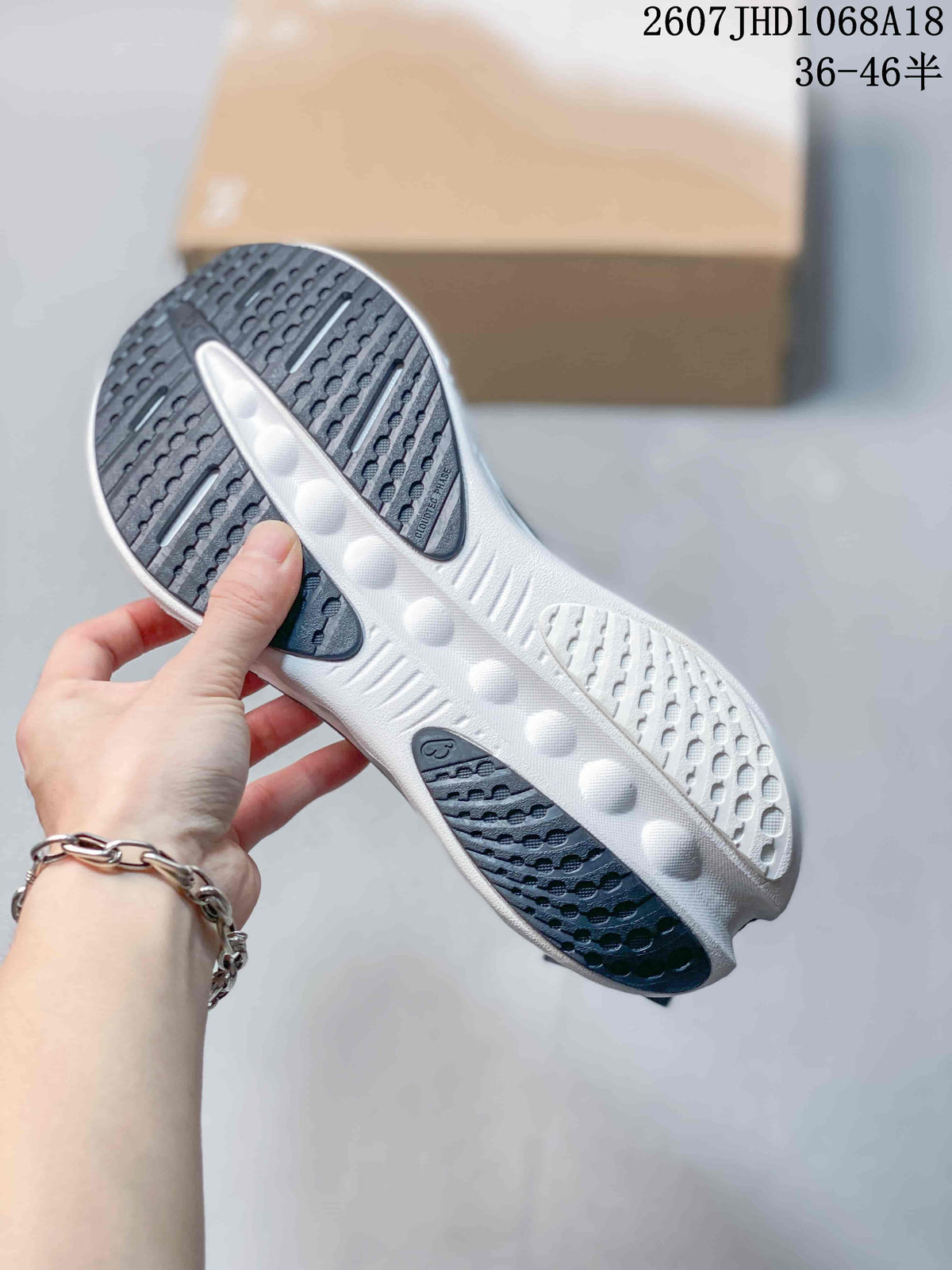 Bottom view of the sneaker showing the black-and-white patterned outsole and sculpted central section.