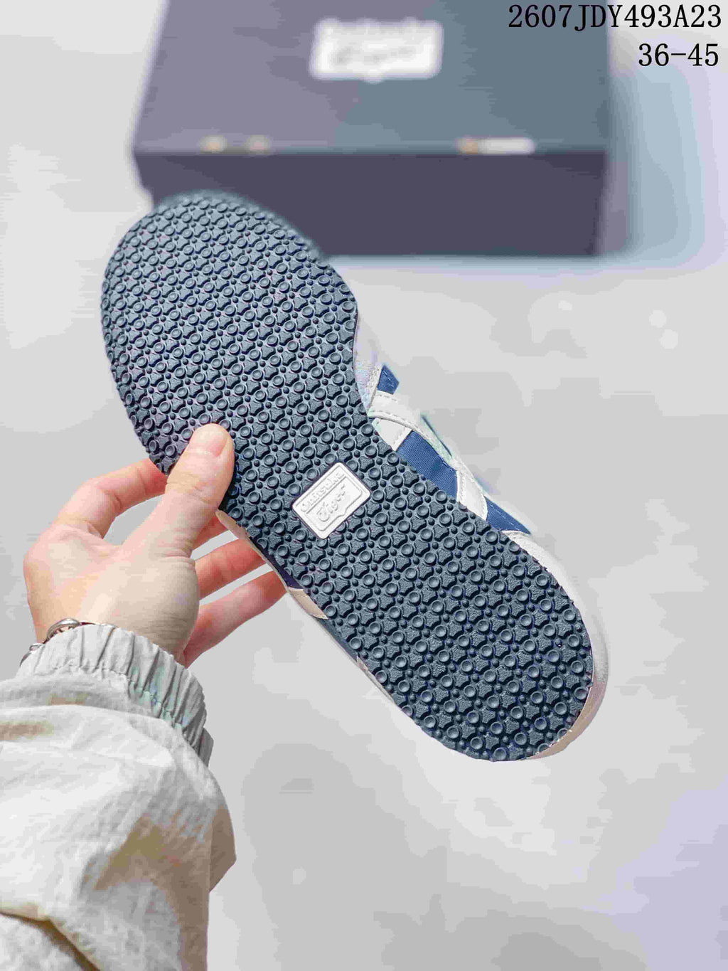 Close view of the textured rubber outsole on a blue and white sneaker; the source overlay shows EU size range 36–45.