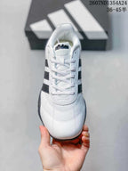 Top view of the lace-up sneaker showing the white upper, tongue branding and black side stripes.